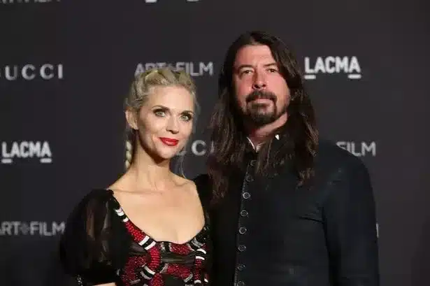 Dave Grohl and wife Jordyn Blum smiling together at a red carpet event before marriage challenges