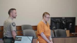 Heavenly Faith Garfield stands in court with officer behind her.